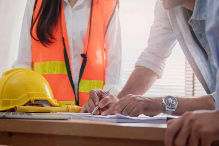 Group, Team of asian, caucasian young colleagues or contractors, engineer brainstorming, discussing and meeting to plan on blueprint,paperwork, on the table at workplace,office.Working people concept.